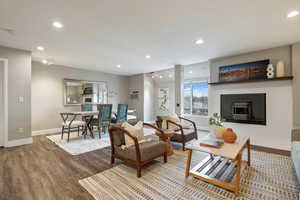 Living room with a tiled fireplace and hardwood / wood-style floors