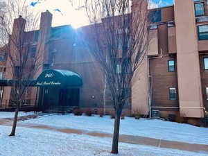 Snow covered property with central AC unit