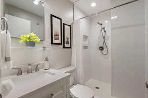 Bathroom with vanity, toilet, and a shower with shower curtain