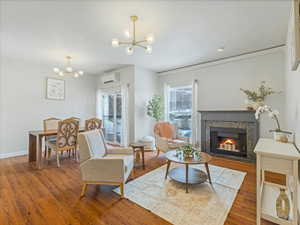 Living room featuring hardwood / wood-style flooring, mini split, and a chandelier