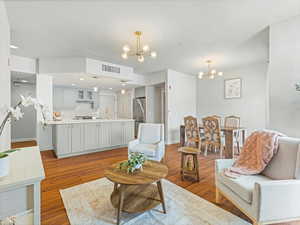 Living room featuring an inviting chandelier, wood-type flooring, and sink