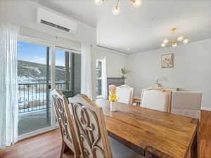 Dining space with a Swaner Preserve view, mini split, light hardwood / wood-style flooring, and a notable chandelier