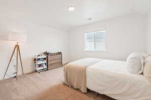 Bedroom with vaulted ceiling and carpet