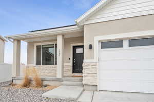 View of exterior entry with a garage and a porch