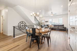 Dining area featuring hardwood / wood-style flooring and ceiling fan with notable chandelier