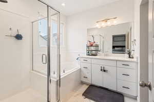 Bathroom featuring vanity and independent shower and bath