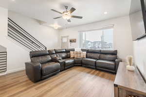 Living room featuring ceiling fan and light hardwood / wood-style flooring
