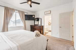 Bedroom featuring light carpet, ceiling fan, and ensuite bathroom