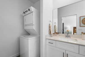 Bathroom with stacked washing maching and dryer and vanity