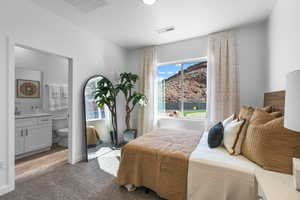 Carpeted bedroom featuring sink and ensuite bath