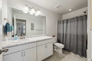 Bathroom featuring tile patterned flooring, vanity, a shower with curtain, and toilet