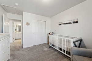 Bedroom featuring light colored carpet, a closet, and a textured ceiling