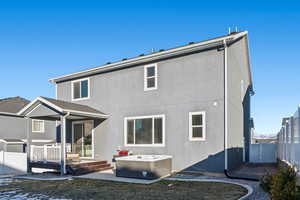 Rear view of property featuring a hot tub