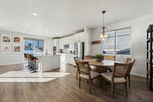 Dining space with sink, dark wood-type flooring, and a chandelier