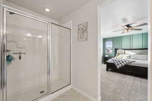 Bathroom with ceiling fan and a shower with shower door