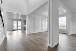 Unfurnished living room with light wood-style flooring and a decorative wall