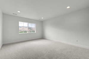 Unfurnished room featuring light carpet, recessed lighting, and a mountain view