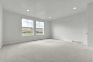 Unfurnished room with light colored carpet and recessed lighting