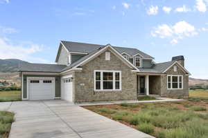 Craftsman inspired home with stone siding, concrete driveway, roof with shingles, an attached garage, and a chimney