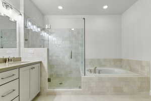 Bathroom featuring a bath, vanity, a shower stall, recessed lighting, and tile patterned flooring
