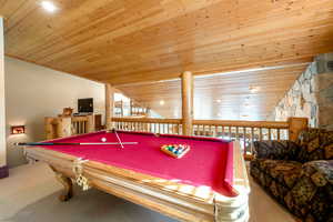 Recreation room featuring lofted ceiling, carpet flooring, and wood ceiling