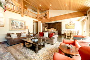 Living room with high vaulted ceiling, a chandelier, and wood ceiling