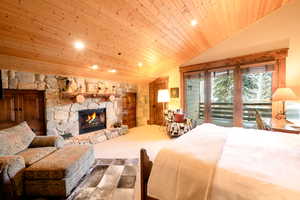 Bedroom featuring access to exterior, lofted ceiling, a fireplace, and wood ceiling