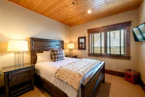 Carpeted bedroom with wood ceiling