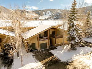 Exterior space with a garage, a balcony, and a mountain view