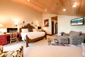 Carpeted bedroom with vaulted ceiling and wooden ceiling