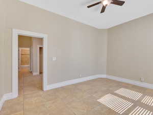 Tiled spare room with ceiling fan