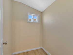 Unfurnished room featuring lofted ceiling and light hardwood / wood-style flooring