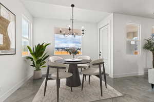 Dining room featuring an inviting chandelier, concrete flooring, and a wealth of natural light