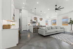 Living room featuring high vaulted ceiling and ceiling fan