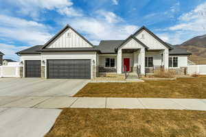 Craftsman inspired home featuring a garage, a front yard, and a porch