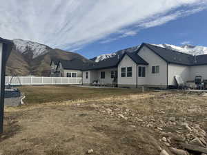 Back of house featuring a yard, a mountain view, and a patio area