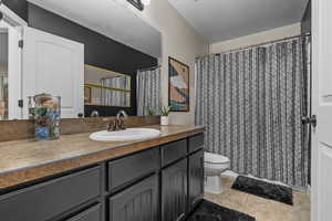 Bathroom with tile patterned flooring, vanity, and toilet