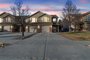 View of property featuring a garage and a yard