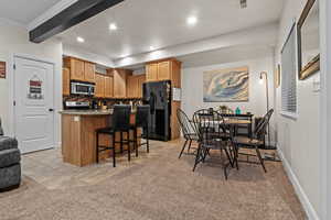 Kitchen with a breakfast bar area, light stone counters, a kitchen island, stainless steel appliances, and backsplash