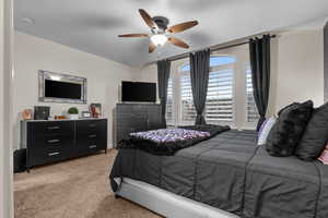 Bedroom with light carpet and ceiling fan