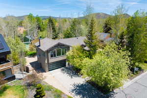 Aerial view of property and surrounding area featuring a mountain backdrop