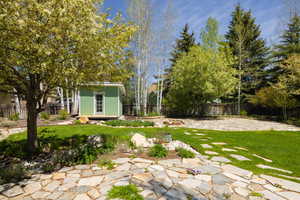 View of yard featuring an outdoor structure and a patio