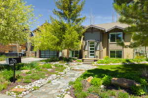 View of front of property featuring concrete driveway, an attached garage, and stucco siding