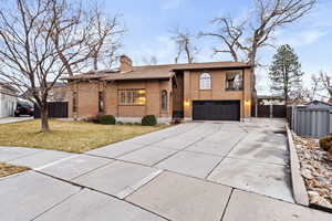 View of front of home with a garage and a front lawn