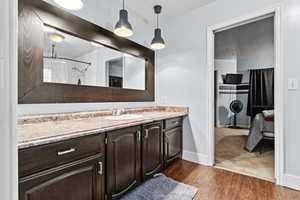 Bathroom featuring a shower with shower curtain, vanity, and hardwood / wood-style floors