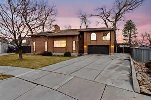 View of front of house with a yard and a garage