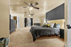 Bedroom featuring a wall mounted air conditioner, access to outside, light colored carpet, ceiling fan, and french doors