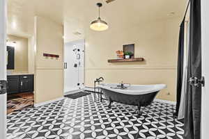 Bathroom featuring vanity, shower with separate bathtub, and a baseboard heating unit