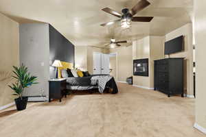 Bedroom featuring ceiling fan, a baseboard heating unit, light colored carpet, and a textured ceiling