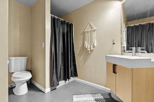 Bathroom featuring tile patterned floors, vanity, and toilet